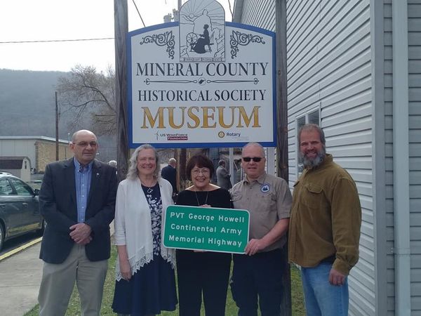 Dinah Courier with a group of colleagues in front of a Mineral County Historical Museum sign 