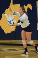 Marissa Earle serving a volleyball